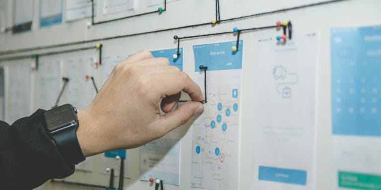 Person planning a website on a wall, using the site tree method.