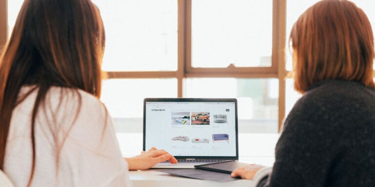 Two women looking at a website on a computer