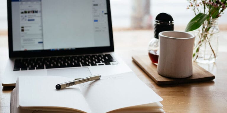 A classic blog set-up. A computer, a notepad and a cup of coffee