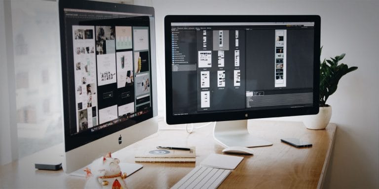 Two computer monitors open, one showing a website plan and the other showing some layout options.